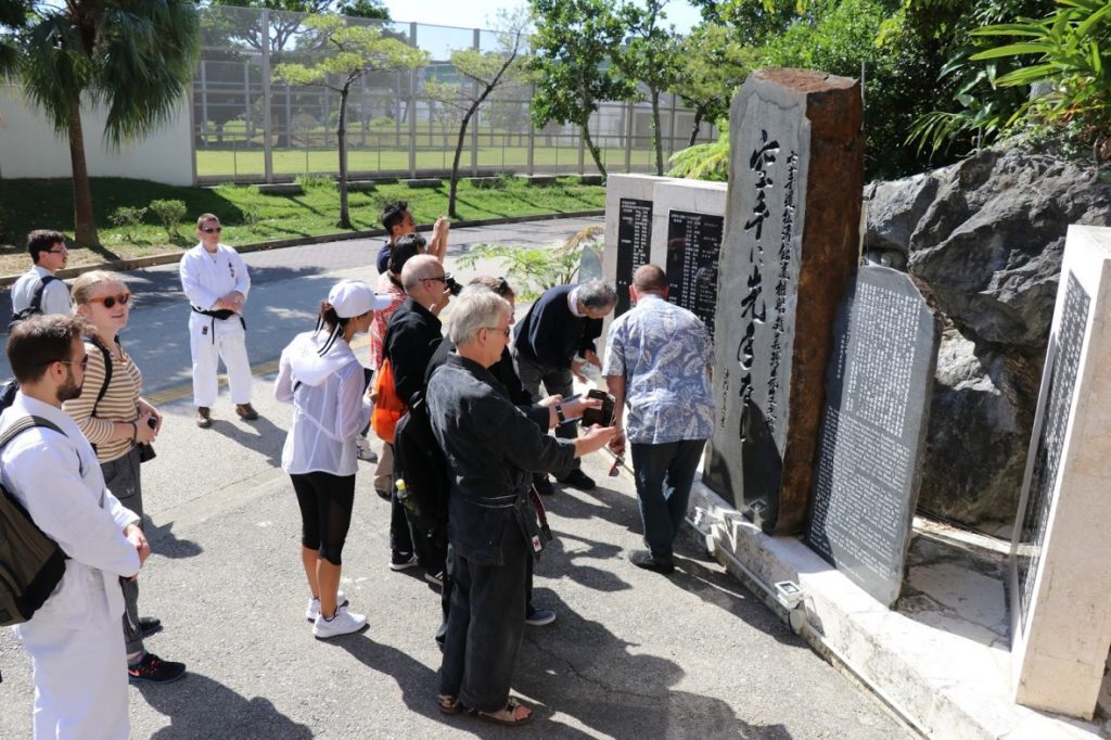 Guided history tour group at a karate monument in Naha