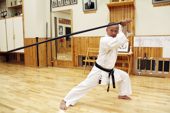 Hiroshi Akamine Sensei performing a bo kata in his dojo
