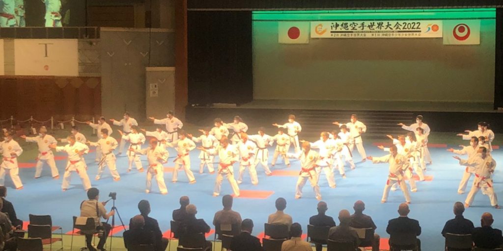 Karateka performing kata on stage at the Okinawa Karate World Tournament 2022