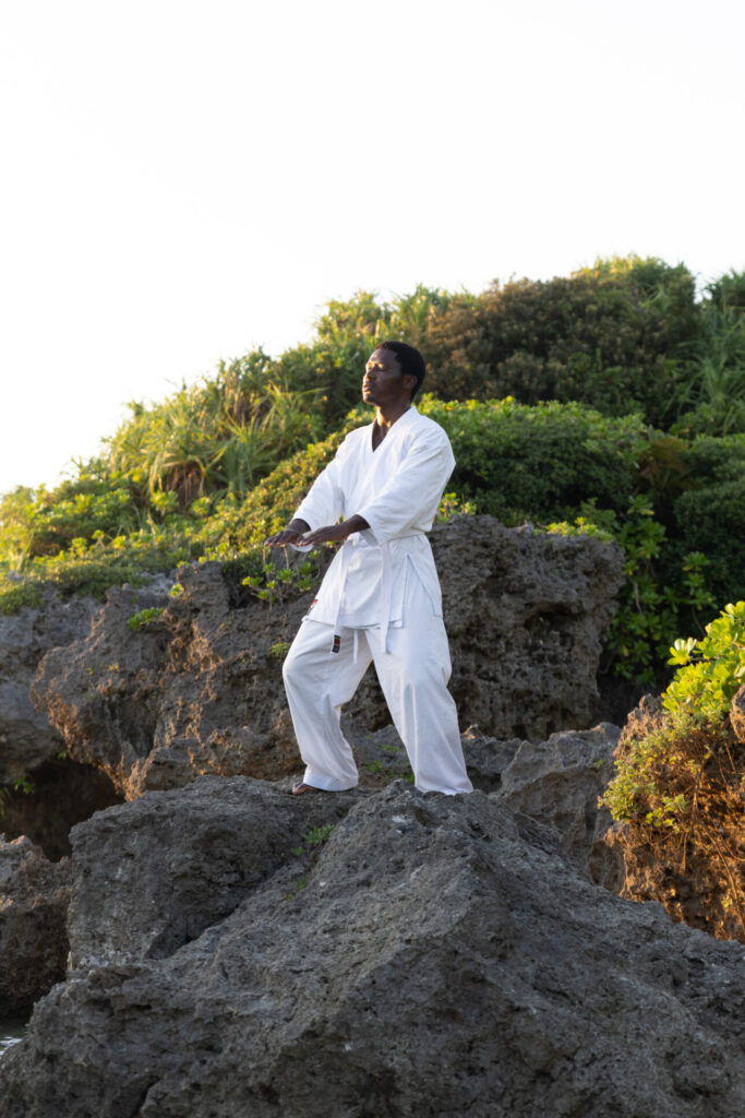 Karateka practising kata on a coastal rock in Okinawa