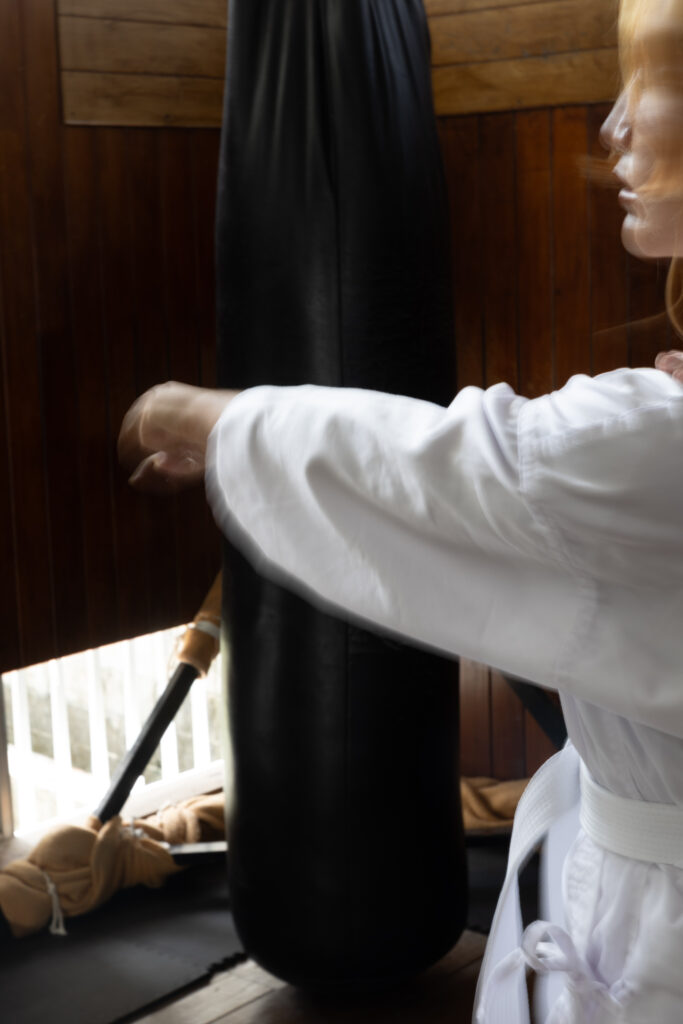 Karateka training at a heavy bag in a traditional dojo