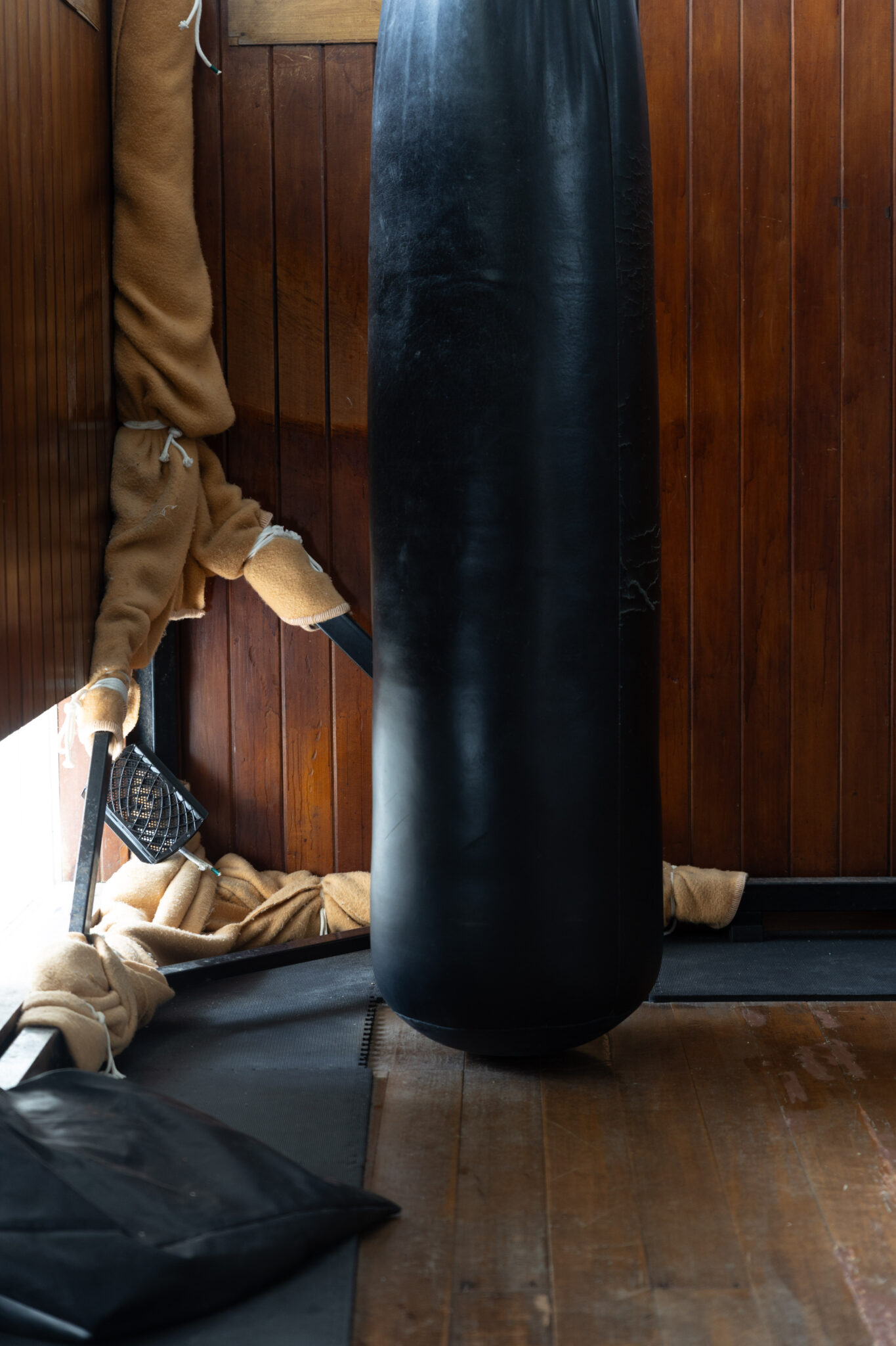 Heavy bag and traditional training equipment in a wooden dojo