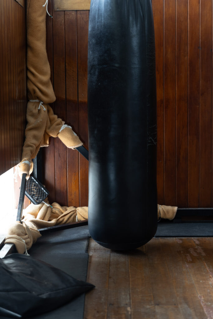Heavy bag and traditional training equipment in a wooden dojo