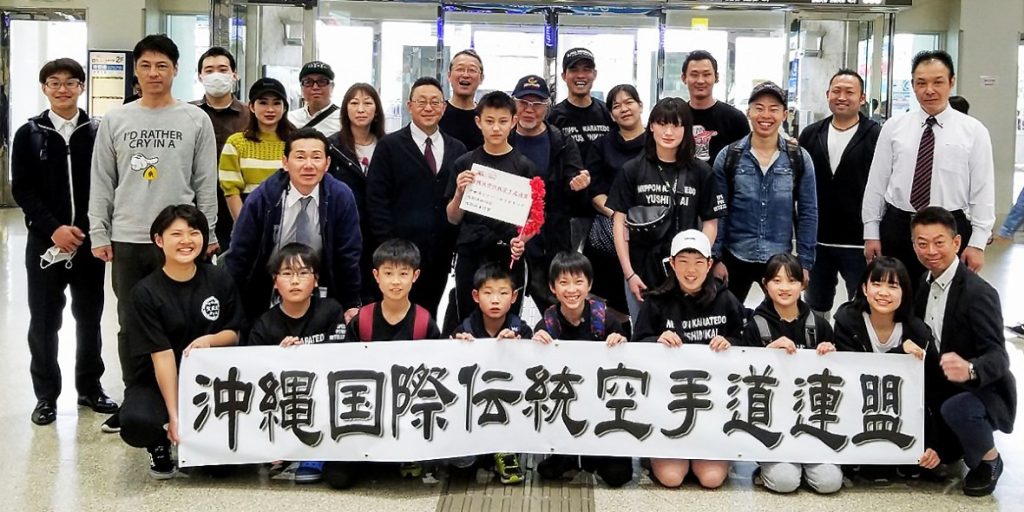 Funakoshi Sensei camp participants with an Okinawa karate federation banner