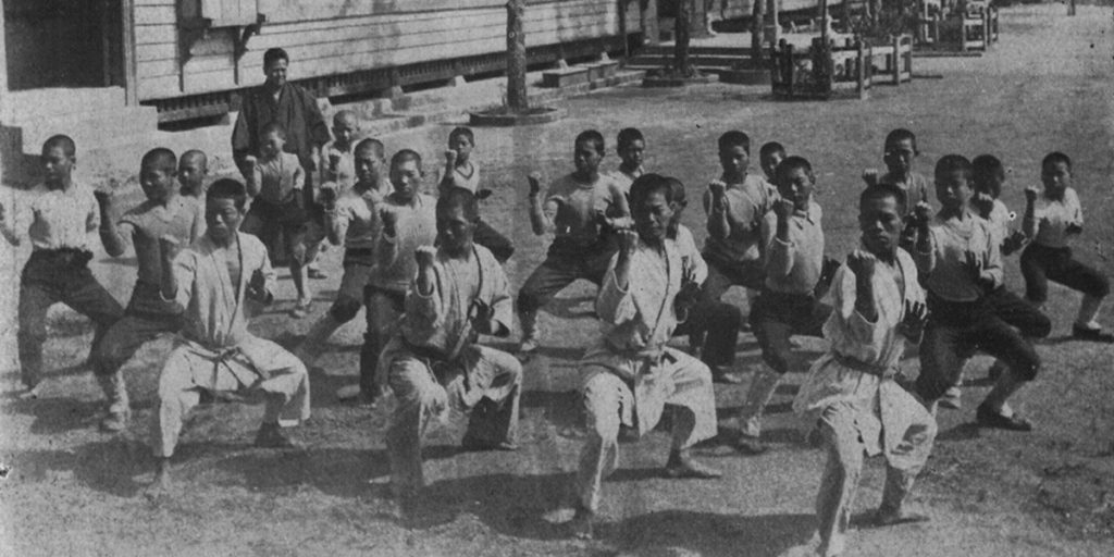Historic photo of students practising karate outdoors