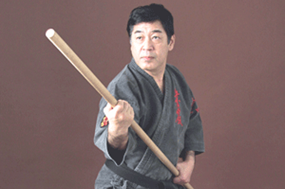 Kiyoshi Yogi Sensei holding a bo staff