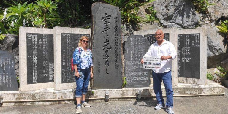 History tour visitors at a karate monument in Okinawa