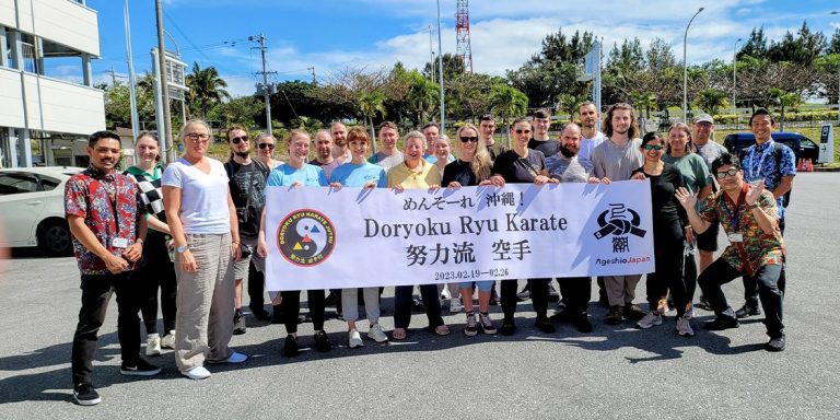 Doryoku Ryu Karate group with their banner in Okinawa, 2023