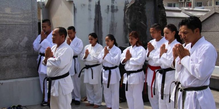 Nepal karate team bowing at a monument on a history tour