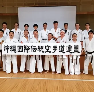 Group tour members holding the Okinawa International Traditional Karate Federation banner